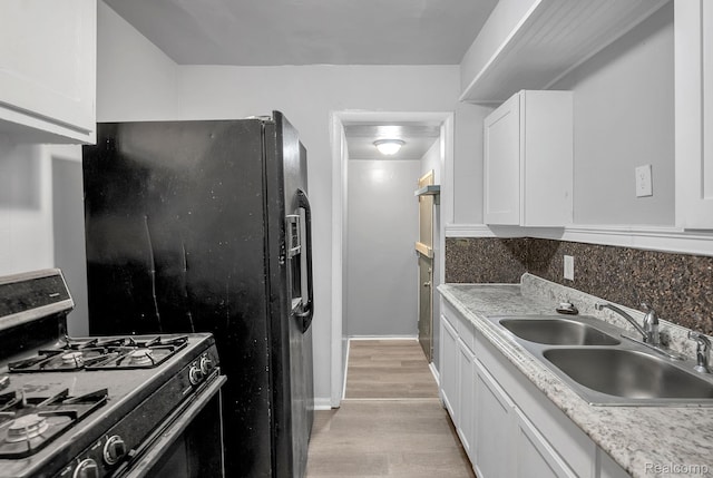 12702-12710 Kelly Rd, Detroit, MI 48224 - kitchen featuring range with gas cooktop, light wood-type flooring, white cabinetry, backsplash, and light countertops