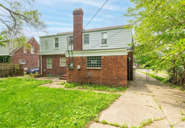 12702-12710 Kelly Rd, Detroit, MI 48224 - rear view of property featuring brick siding, a gate, and a chimney