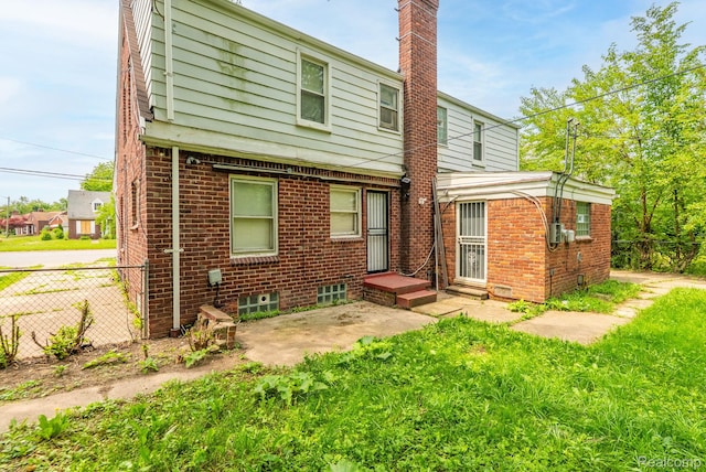 12702-12710 Kelly Rd, Detroit, MI 48224 - rear view of house with a chimney, brick siding, and a patio area