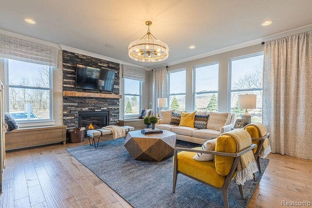 16245 Rogan Dr, Linden, MI 48451 - living room with a chandelier, crown molding, a fireplace, light wood-style flooring, and recessed lighting