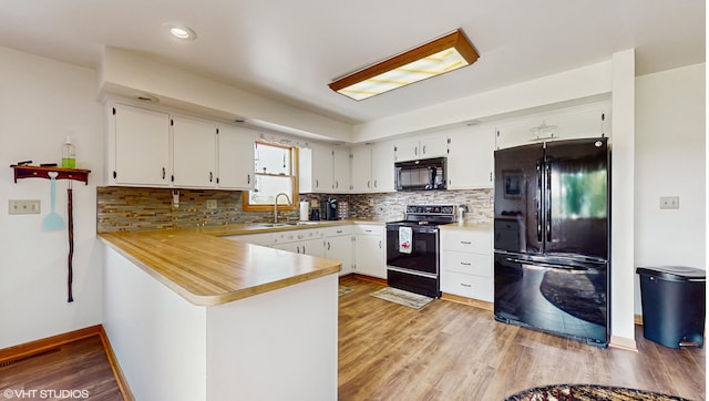 16486 Three Oaks Rd, Three Oaks, MI 49128 - kitchen featuring black appliances, a peninsula, backsplash, a sink, and recessed lighting