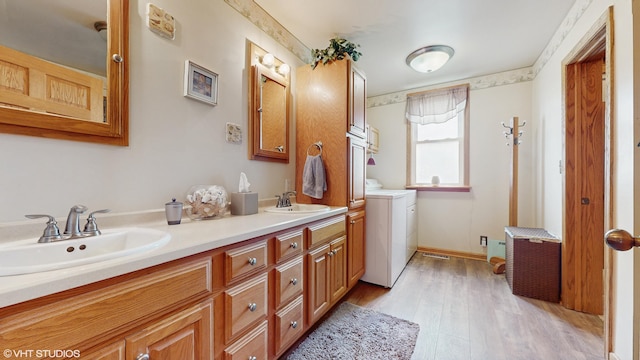 16486 Three Oaks Rd, Three Oaks, MI 49128 - bathroom featuring washer and clothes dryer, double vanity, and wood finished floors