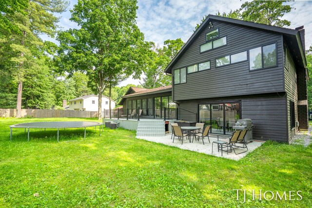 2605 Shadowbrook Dr SE, Grand Rapids, MI 49546 - back of house with a trampoline, central AC, a patio, and a sunroom