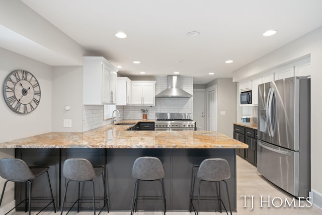 2605 Shadowbrook Dr SE, Grand Rapids, MI 49546 - kitchen featuring stainless steel appliances, wall chimney exhaust hood, a sink, a peninsula, and white cabinetry