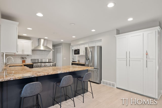 2605 Shadowbrook Dr SE, Grand Rapids, MI 49546 - kitchen with stainless steel fridge with ice dispenser, wall chimney range hood, stove, a sink, and a peninsula