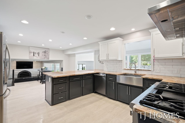 2605 Shadowbrook Dr SE, Grand Rapids, MI 49546 - kitchen featuring stainless steel appliances, a sink, extractor fan, white cabinets, and light stone countertops
