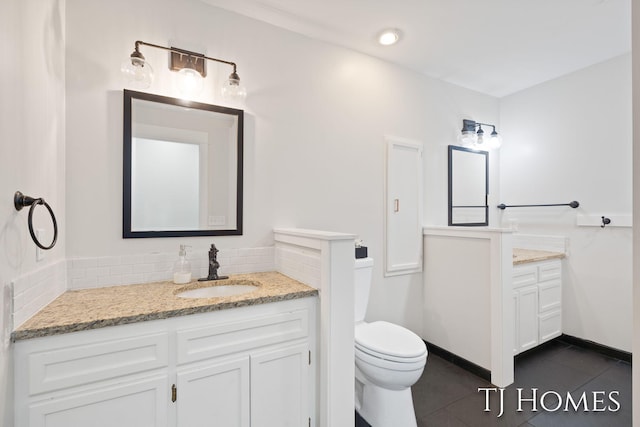 2605 Shadowbrook Dr SE, Grand Rapids, MI 49546 - bathroom with vanity, tile patterned floors, toilet, tasteful backsplash, and baseboards