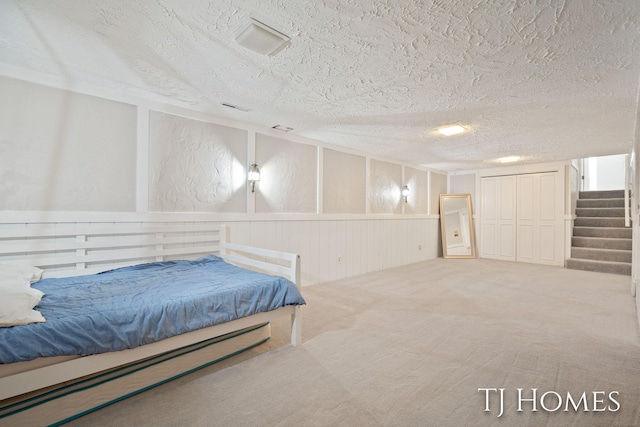 2605 Shadowbrook Dr SE, Grand Rapids, MI 49546 - carpeted bedroom featuring a textured ceiling and a decorative wall