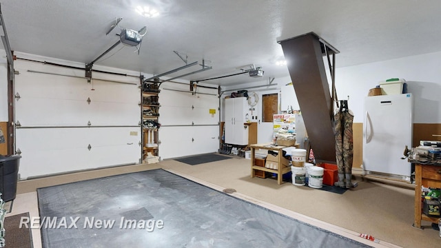 2258 High Rd, Roscommon, MI 48653 - garage featuring a garage door opener and freestanding refrigerator