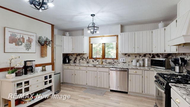 2258 High Rd, Roscommon, MI 48653 - kitchen with stainless steel appliances, custom range hood, backsplash, light wood-style flooring, and light stone counters