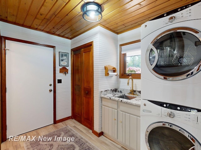 2258 High Rd, Roscommon, MI 48653 - laundry room featuring stacked washer / dryer, wood ceiling, cabinet space, light wood-type flooring, and crown molding