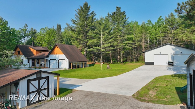 2258 High Rd, Roscommon, MI 48653 - view of side of property with an outdoor structure, a detached garage, and a lawn