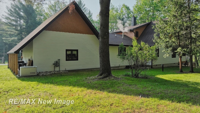 2258 High Rd, Roscommon, MI 48653 - view of side of home with a lawn and roof with shingles