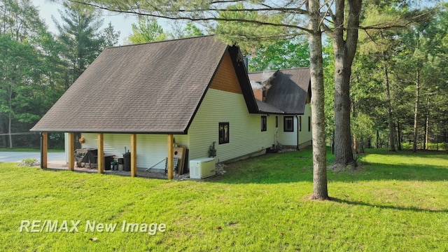 2258 High Rd, Roscommon, MI 48653 - view of side of home with a lawn and a shingled roof