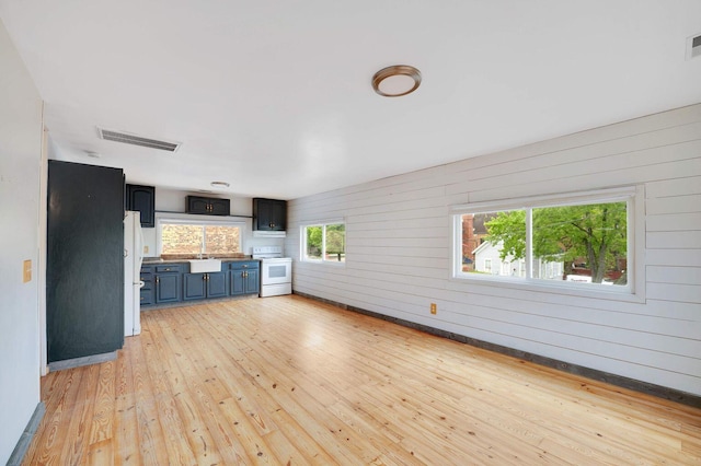617 Elm St, Saint Joseph, MI 49085 - unfurnished living room with light wood-style floors and wood walls