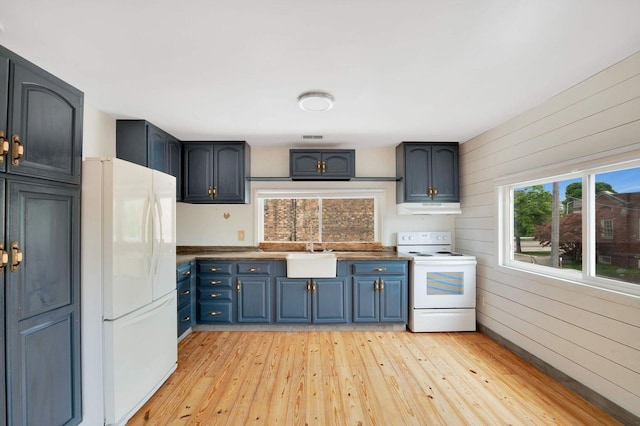 617 Elm St, Saint Joseph, MI 49085 - kitchen with white appliances, under cabinet range hood, light wood-style floors, a sink, and dark countertops