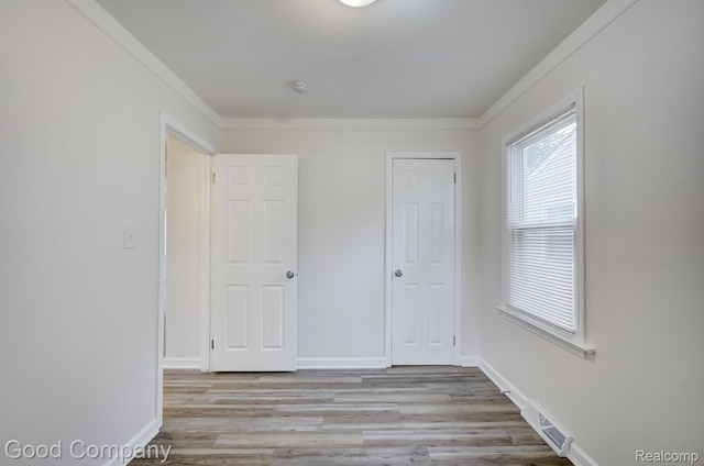 22811 Sharrow Ave, Utica, MI 48089 - unfurnished bedroom featuring crown molding and light wood-style flooring