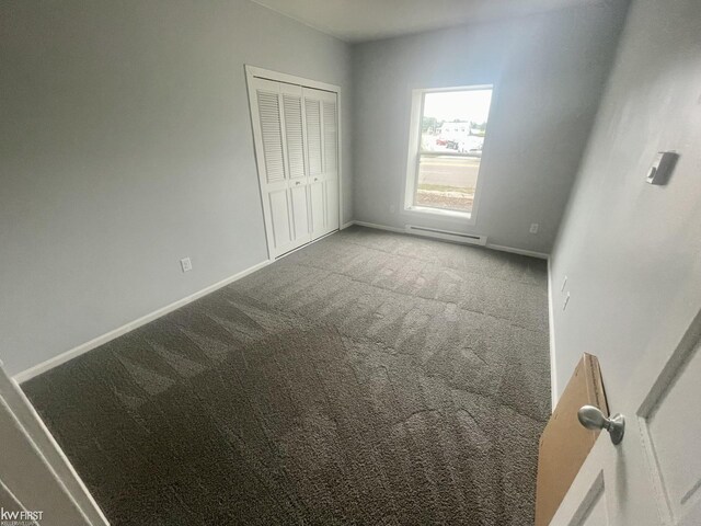 11009 N Saginaw St, Mount Morris, MI 48458 - unfurnished bedroom featuring carpet flooring, baseboards, a closet, and a baseboard radiator