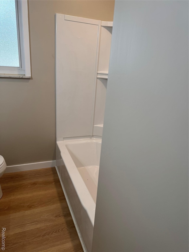 4227 Crooks Rd, Fenton, MI 48073 - bathroom with toilet, wood finished floors, a tub to relax in, and baseboards