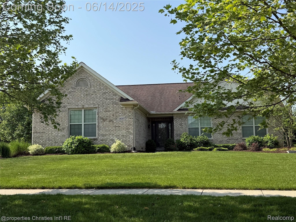 58307 Holland Dr, South Lyon, MI 48178 - view of front facade featuring a front lawn and brick siding