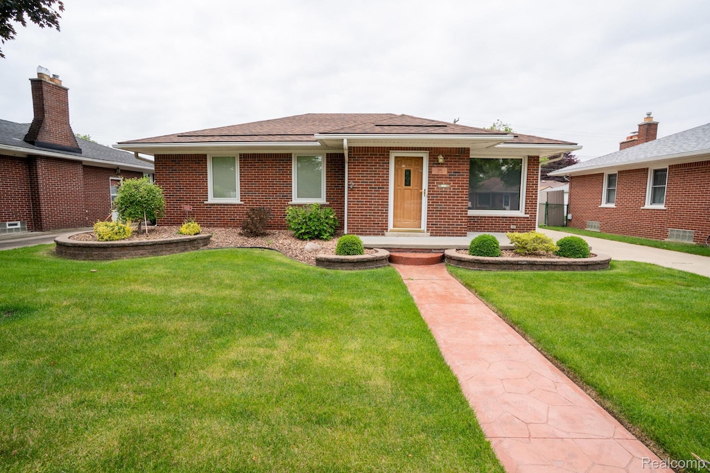 3160 Anna Ave, Trenton, MI 48183 - view of front facade featuring brick siding, a front yard, and a shingled roof