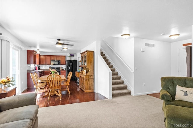 1029 Primrose Ln, Milan, MI 48160 - living area featuring stairway, ceiling fan, and dark colored carpet