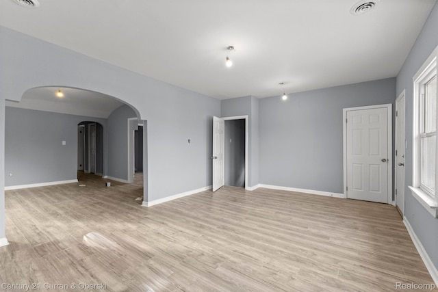 2633 Monterey St, Detroit, MI 48206 - spare room featuring arched walkways, baseboards, and light wood finished floors