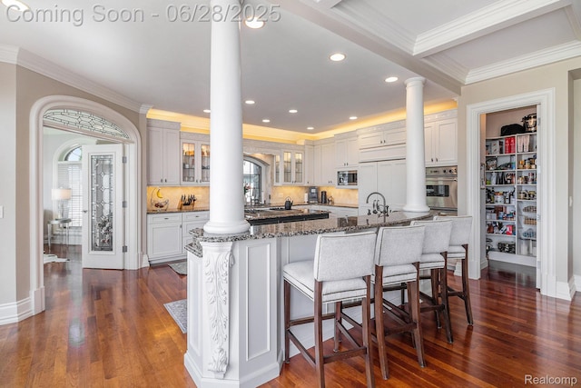 13123 Log Cabin Pt, Fenton, MI 48430 - kitchen featuring ornate columns, built in appliances, crown molding, dark stone countertops, and glass insert cabinets