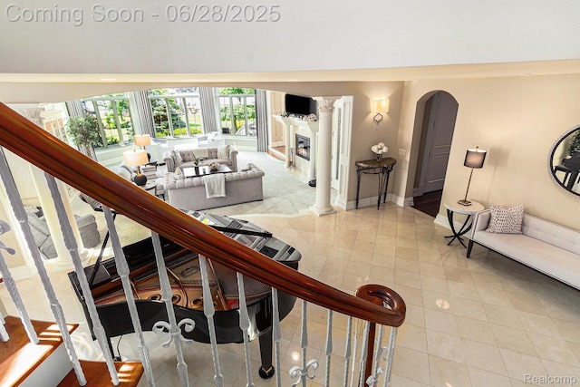 13123 Log Cabin Pt, Fenton, MI 48430 - stairs with tile patterned floors, a glass covered fireplace, and arched walkways