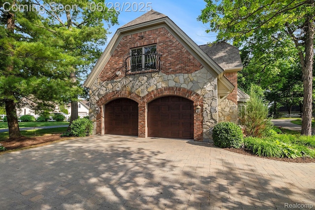13123 Log Cabin Pt, Fenton, MI 48430 - english style home featuring stone siding, driveway, roof with shingles, brick siding, and a garage