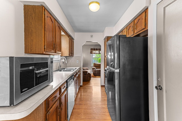 7491 Dacosta, Redford, MI 48239 - kitchen featuring stainless steel appliances, a sink, light countertops, arched walkways, and light wood-type flooring