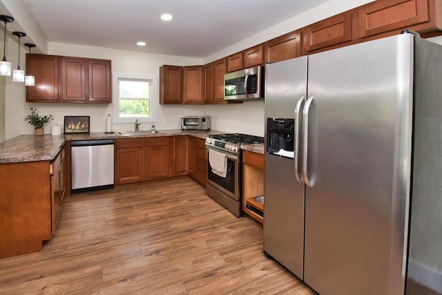 8974 M-140, Berrien Center, MI 49102 - kitchen with stainless steel appliances, recessed lighting, light wood-style flooring, brown cabinets, and decorative light fixtures