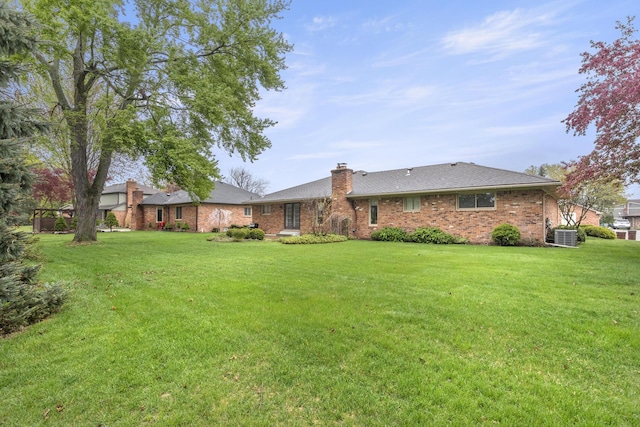 47545 Andrea Ct, Michigan, MI 48315 - back of property with brick siding, a chimney, a yard, and central AC
