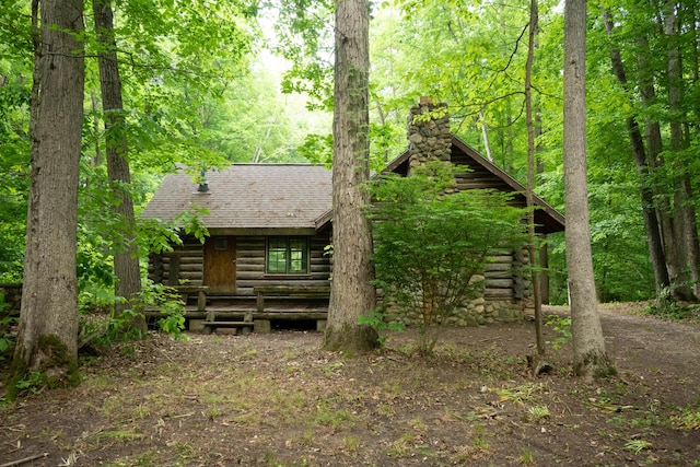 4286 Watson Rd, Eau Claire, MI 49111 - view of front of property with a chimney, a shingled roof, log exterior, and a forest view