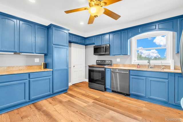 5276 Van Orden Rd, Webberville, MI 48892 - kitchen with stainless steel appliances, blue cabinetry, a sink, light countertops, and recessed lighting