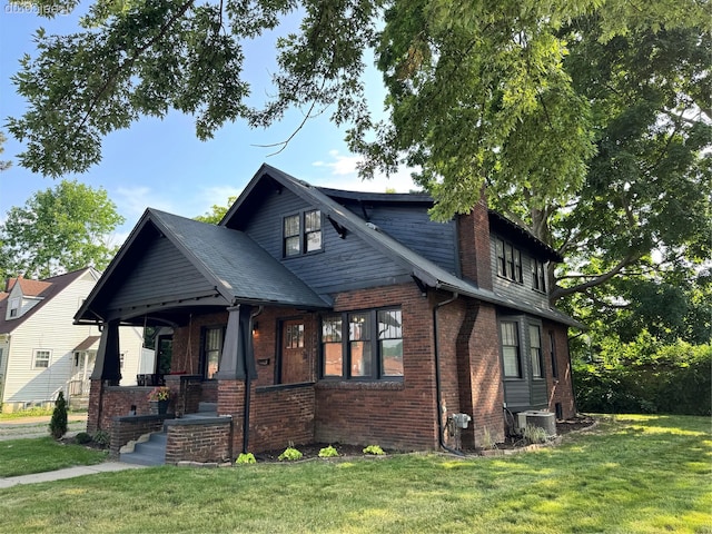 1202 Pershing St, Flint, MI 48503 - view of front of house with covered porch, a front yard, brick siding, and a chimney