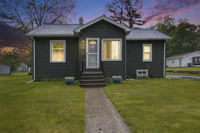 51 Dunning Ave, Battle Creek, MI 49037 - bungalow-style house with a chimney, a yard, entry steps, and roof with shingles