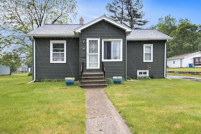 51 Dunning Ave, Battle Creek, MI 49037 - view of front of house featuring entry steps, a front lawn, a chimney, and a shingled roof