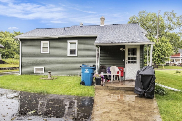 51 Dunning Ave, Battle Creek, MI 49037 - back of property with a yard, roof with shingles, and a chimney