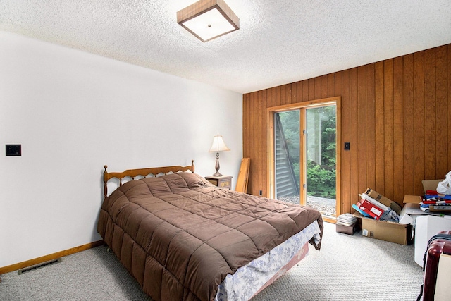 441 N Benson Rd, Fountain, MI 49410 - bedroom with carpet flooring, wood walls, a textured ceiling, access to outside, and baseboards