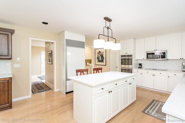6524 Pleasant Lake Ct, West Bloomfield, MI 48322 - kitchen featuring stainless steel appliances, light countertops, backsplash, light wood-style floors, and a center island