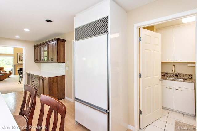 6524 Pleasant Lake Ct, West Bloomfield, MI 48322 - kitchen featuring paneled built in refrigerator, light wood-style floors, light stone countertops, decorative backsplash, and recessed lighting