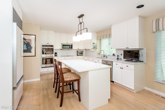 6524 Pleasant Lake Ct, West Bloomfield, MI 48322 - kitchen with appliances with stainless steel finishes, tasteful backsplash, and light wood-style flooring