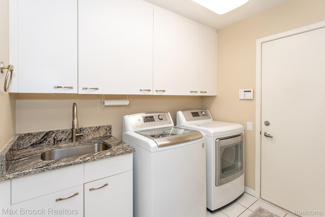 6524 Pleasant Lake Ct, West Bloomfield, MI 48322 - laundry area featuring washing machine and dryer, cabinet space, and light tile patterned floors