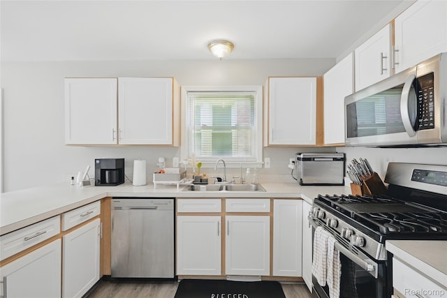 1372 Maryland St, Grosse Pointe, MI 48230 - kitchen with stainless steel appliances, white cabinets, light countertops, and light wood-style floors