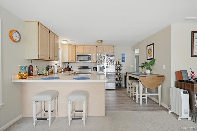1372 Maryland St, Grosse Pointe, MI 48230 - kitchen featuring stainless steel appliances, light countertops, a kitchen breakfast bar, a peninsula, and light brown cabinetry