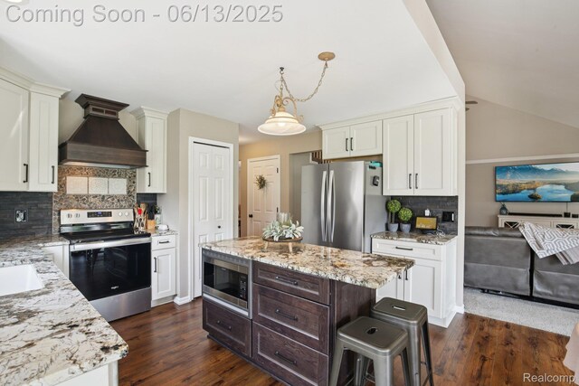 8329 Deer Creek Ct, Grand Blanc, MI 48439 - kitchen with custom exhaust hood, stainless steel appliances, backsplash, dark wood finished floors, and lofted ceiling