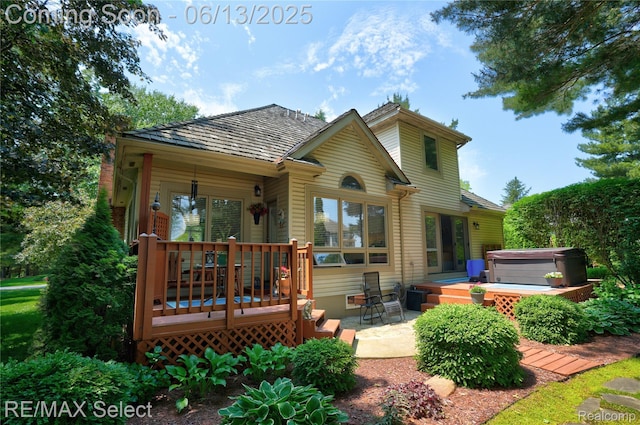 16483 Dawnlight Dr, Fenton, MI 48430 - back of house featuring a hot tub, a wooden deck, and a patio