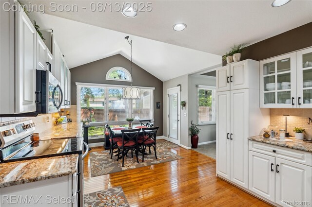 16483 Dawnlight Dr, Fenton, MI 48430 - kitchen with appliances with stainless steel finishes, white cabinets, light wood-style floors, decorative backsplash, and vaulted ceiling