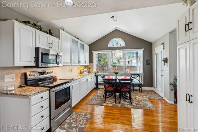 16483 Dawnlight Dr, Fenton, MI 48430 - kitchen featuring stainless steel appliances, light wood-style flooring, white cabinetry, vaulted ceiling, and backsplash